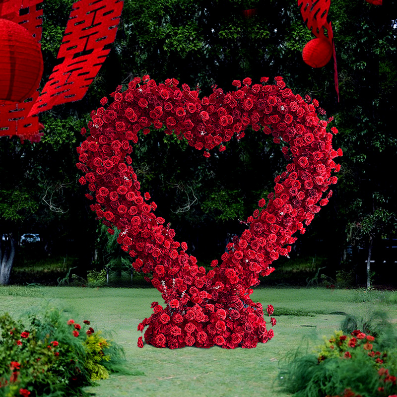 The romantic heart-shaped red rose arch wedding ceremony area is decorated with festive outdoor lawns