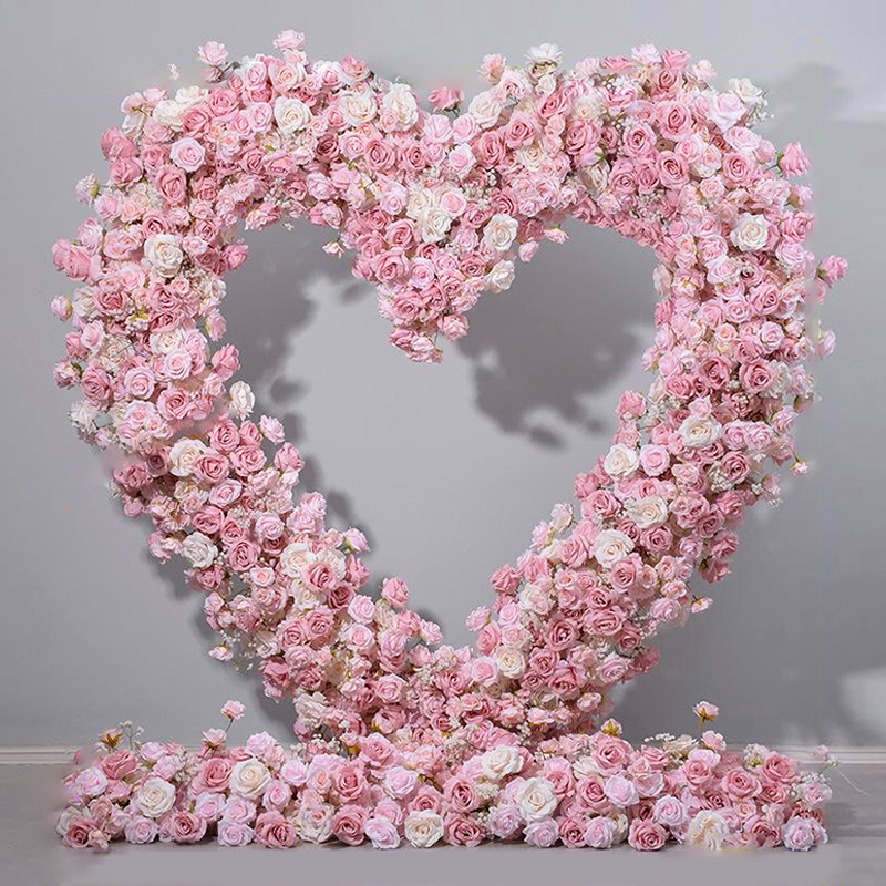 A pink and white gradient heart-shaped floral installation for wedding venue decoration